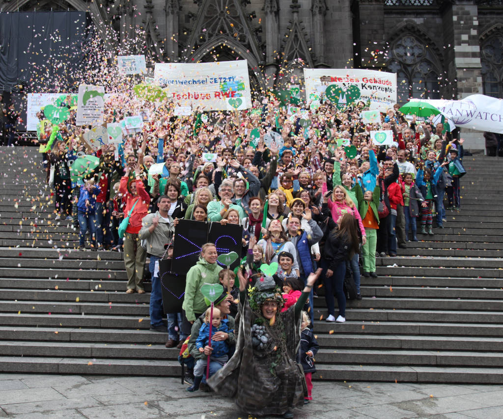 400 Menschen formen auf den Stufen zum Kölner Dom ein großes grünes Herz, singen  und werfen Blütenblätter!